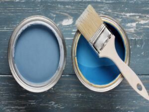 Blue paint cans with brush.