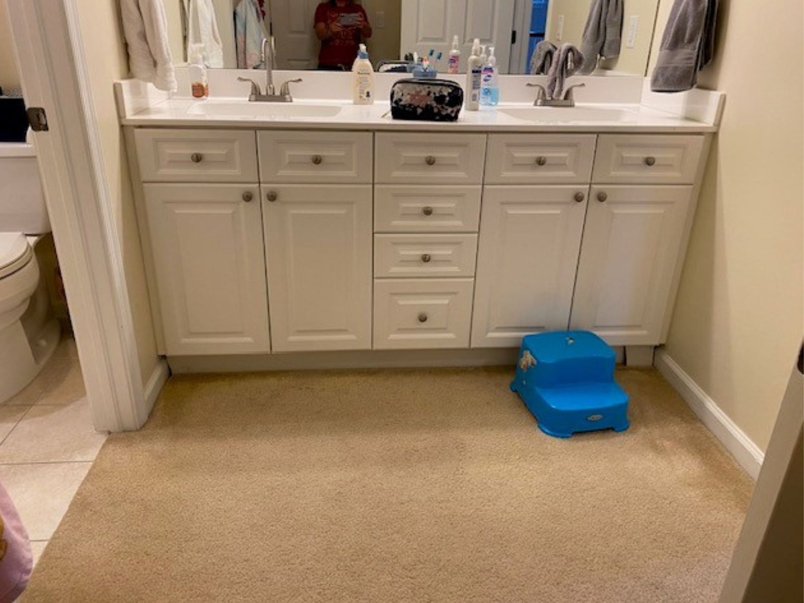 White bathroom vanity with blue step stool.